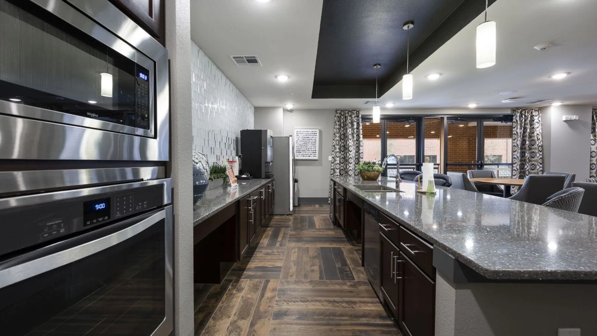 a kitchen with stainless steel appliances and wood floors at The Steelyard Apartments