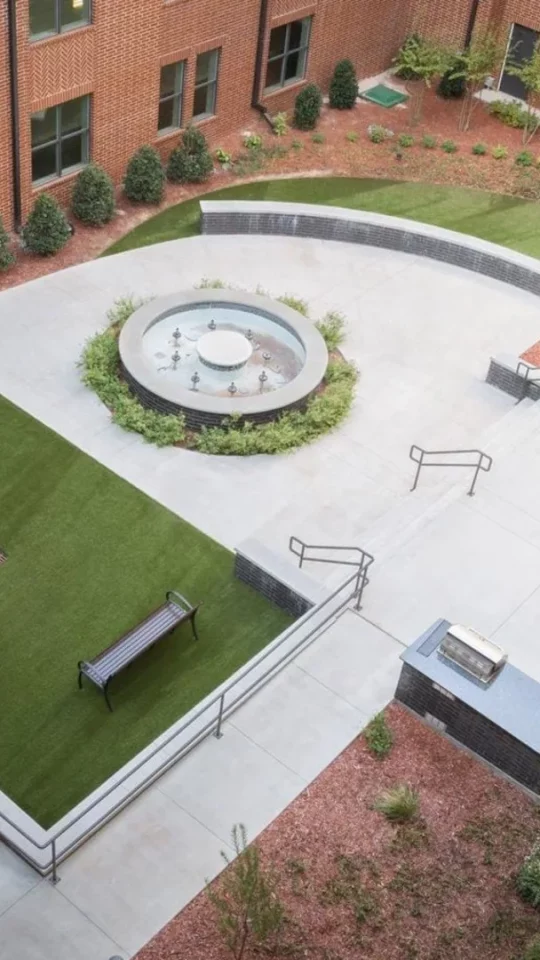 an aerial view of a courtyard with a fountain and a lawn at The Steelyard Apartments