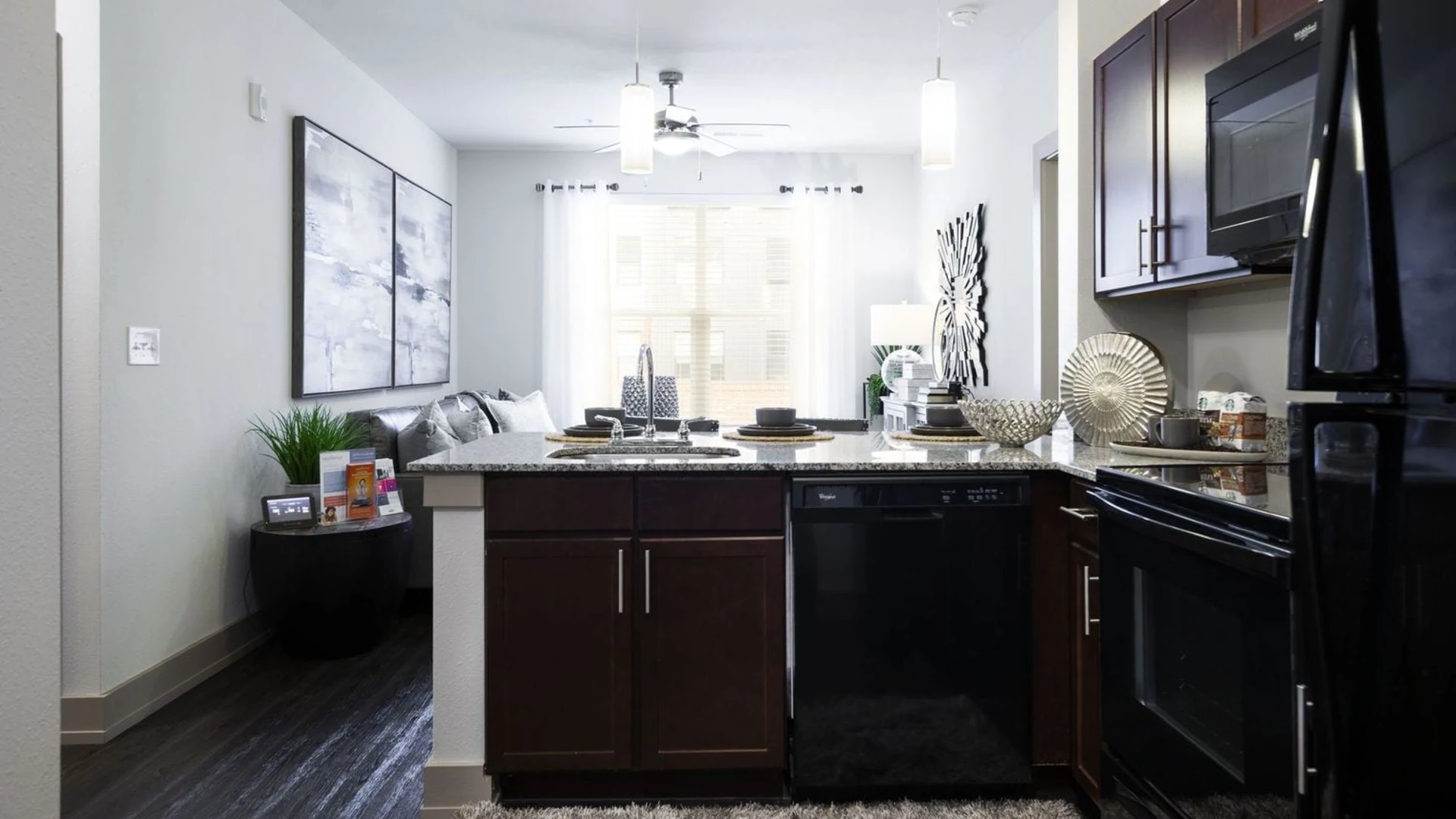 a kitchen with black appliances and wood cabinets at The Steelyard Apartments