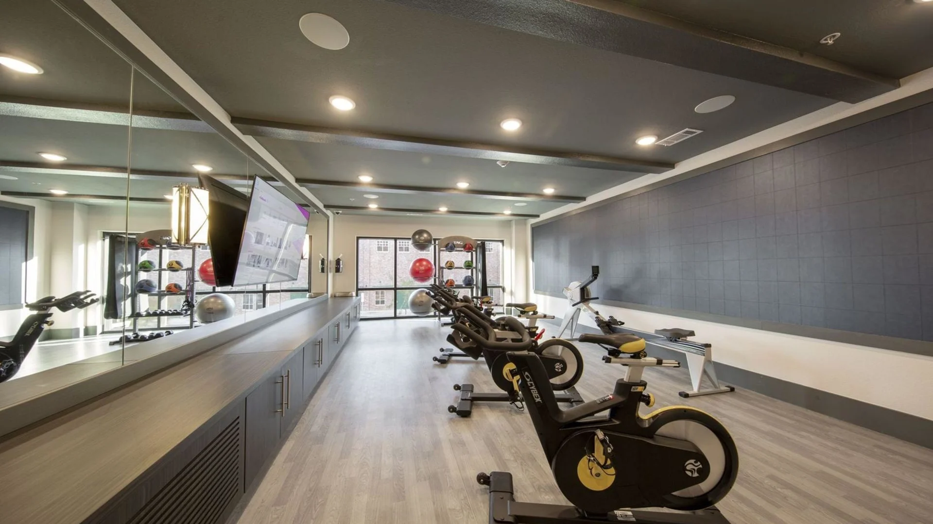 a gym room with exercise equipment and mirrors at The Steelyard Apartments