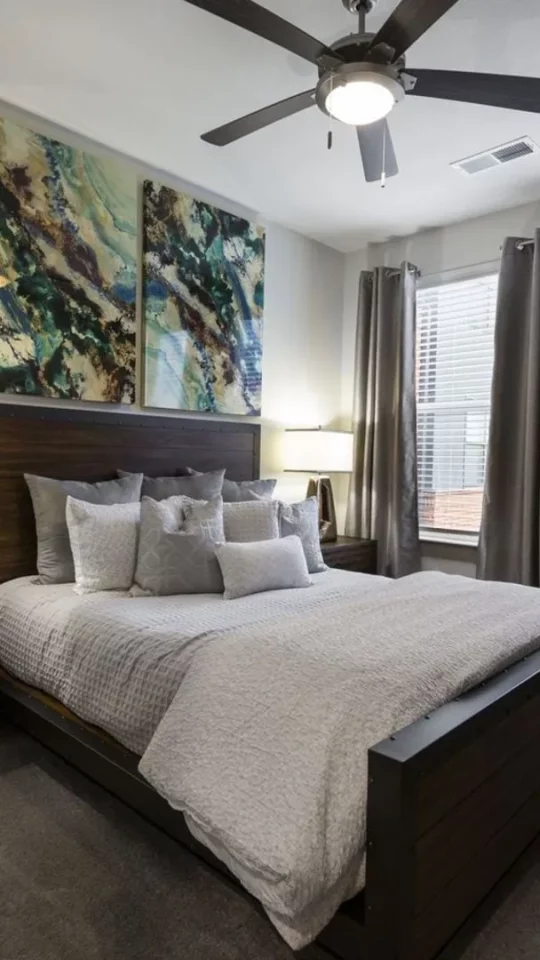 a bedroom with a large bed and ceiling fan at The Steelyard Apartments