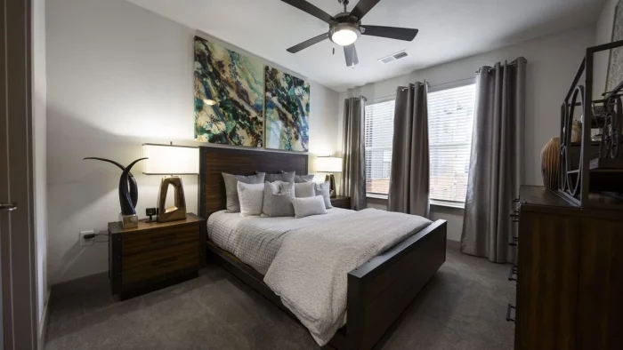 a bedroom with a large bed and ceiling fan at The Steelyard Apartments