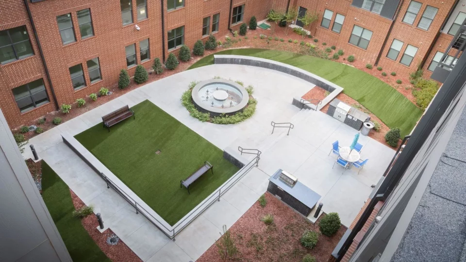 an aerial view of a courtyard with a fountain and a lawn at The Steelyard Apartments