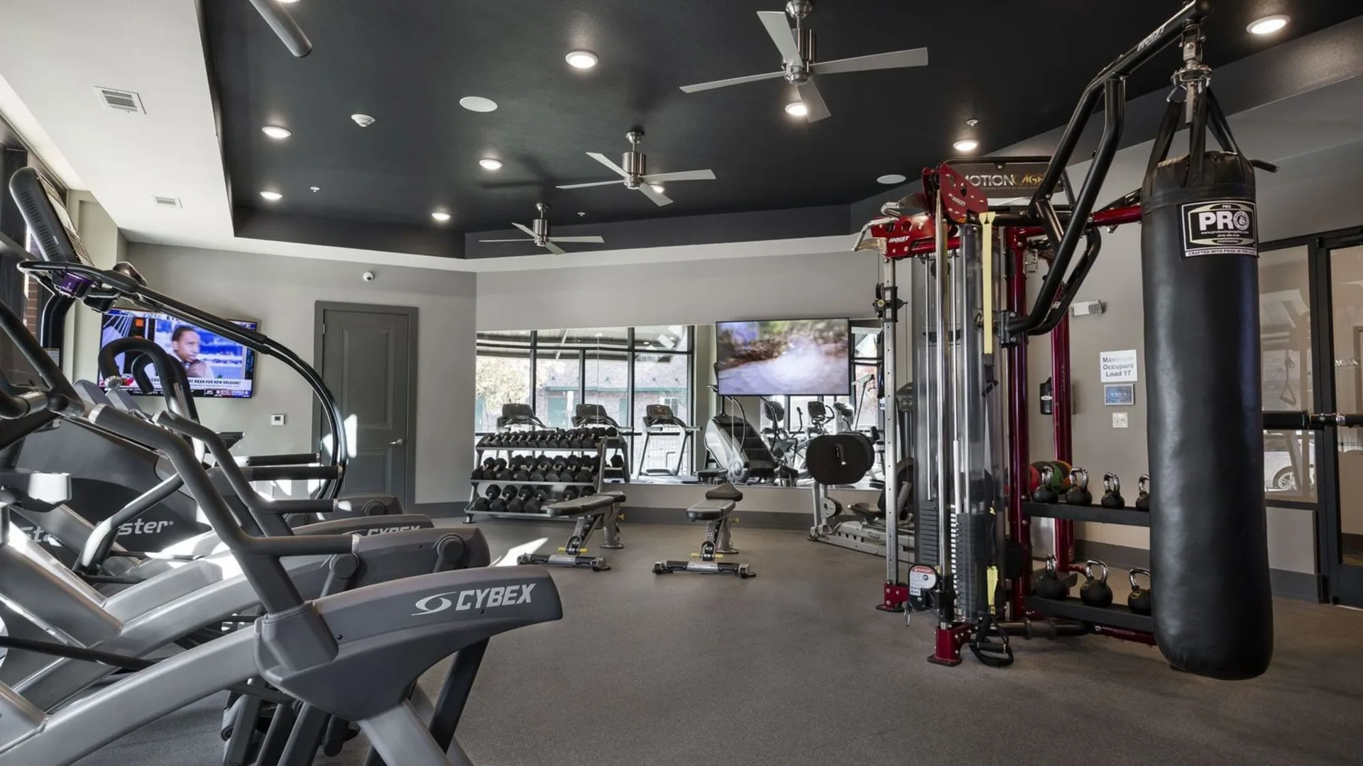 a gym room with exercise equipment and a television at The Steelyard Apartments