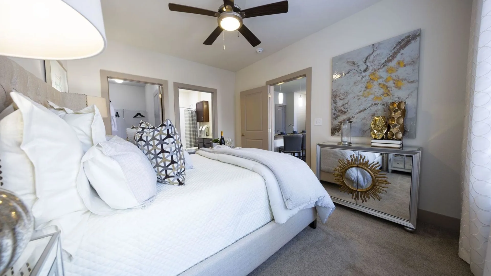 a bedroom with a white bed and ceiling fan at The Steelyard Apartments