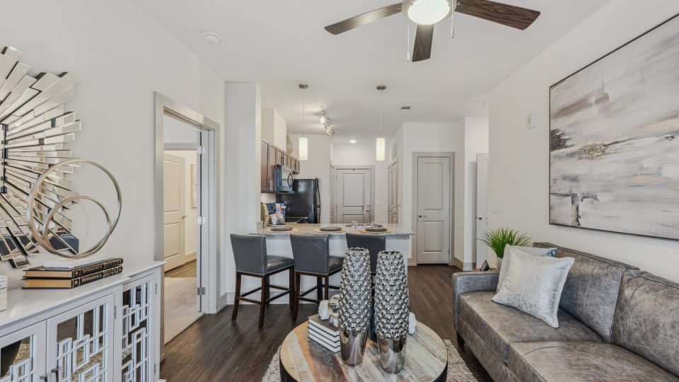 the living room has a ceiling fan and a couch at The Steelyard Apartments