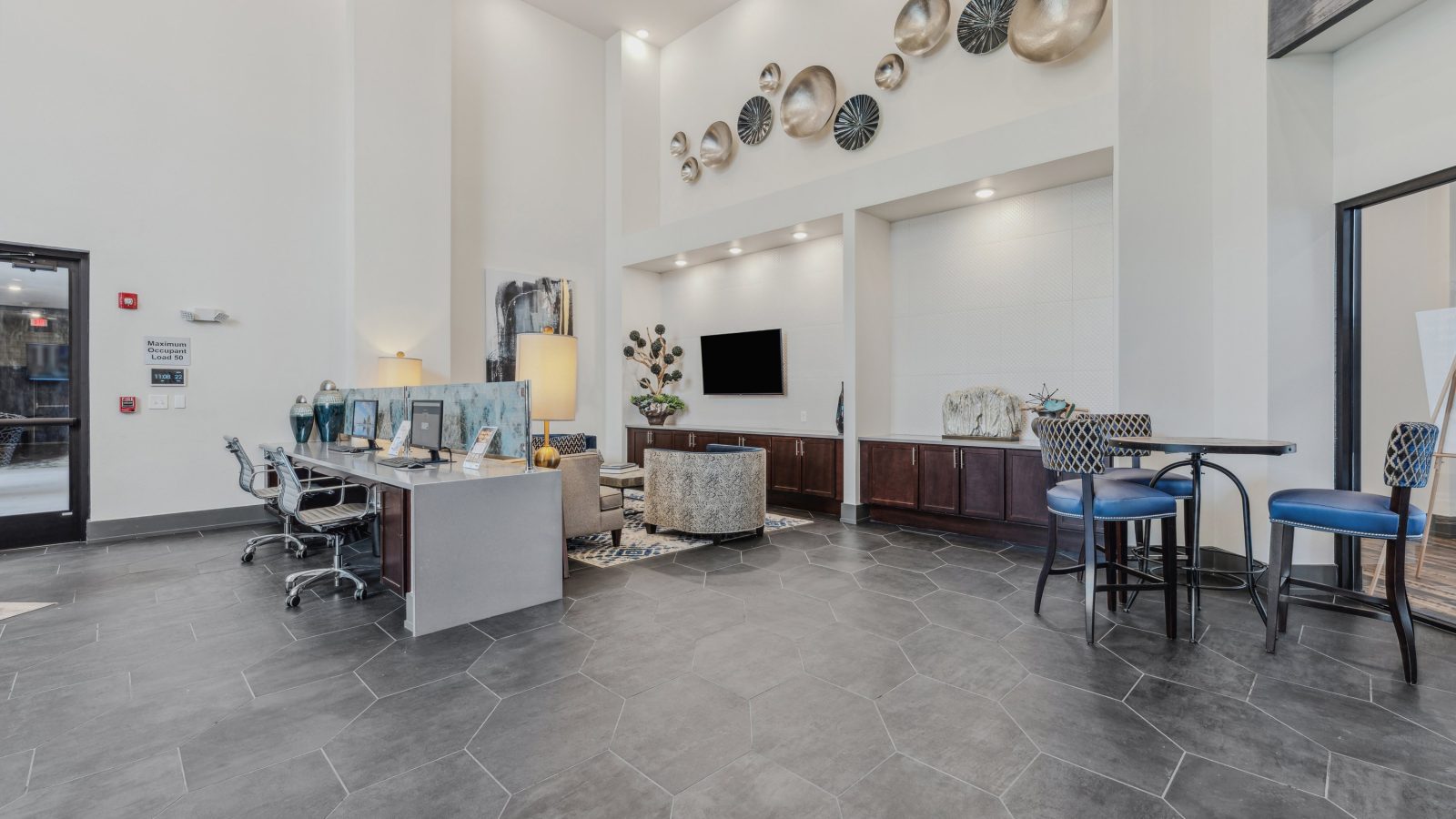 the lobby of a large apartment building with a large flat screen tv at The Steelyard Apartments